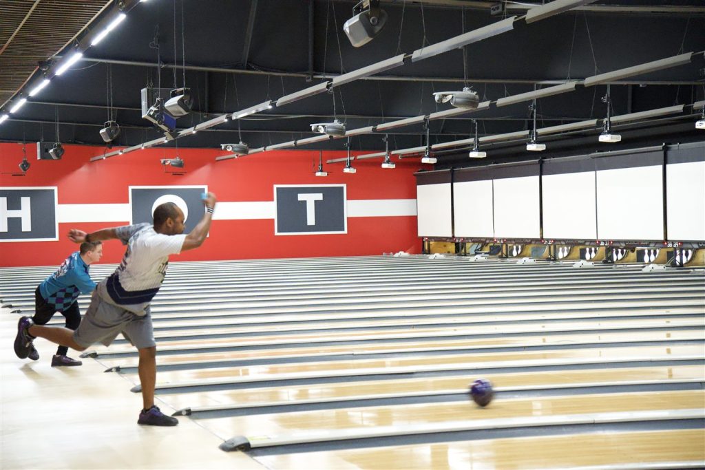 Bowler releasing a ball during UBA competition on indoor bowling lanes